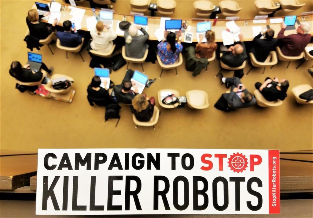 Campaign to Stop Killer Robots tarra ja taustalla ihmisiä istuntosalissa